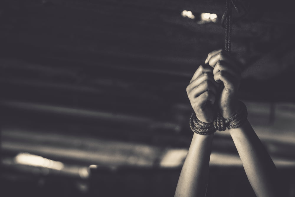 Hands tied to the ceiling to illustrate california torture law 206 (PC)