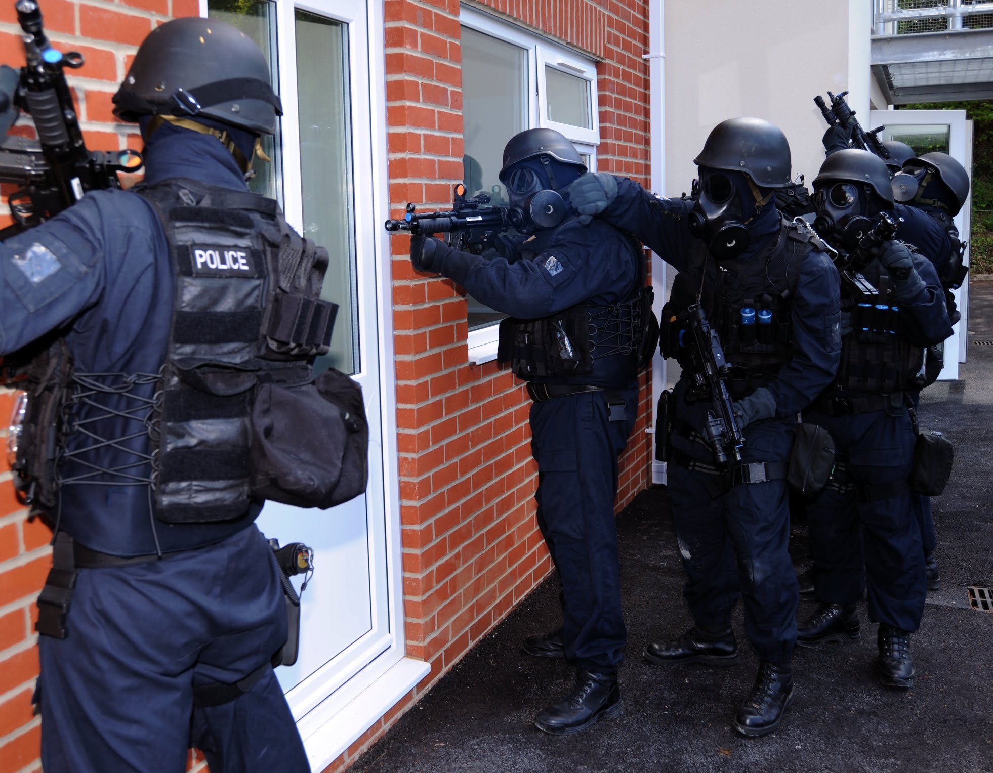 An armed police unit wait to enter a building used to illustrate swatting crimes under Vista, California law