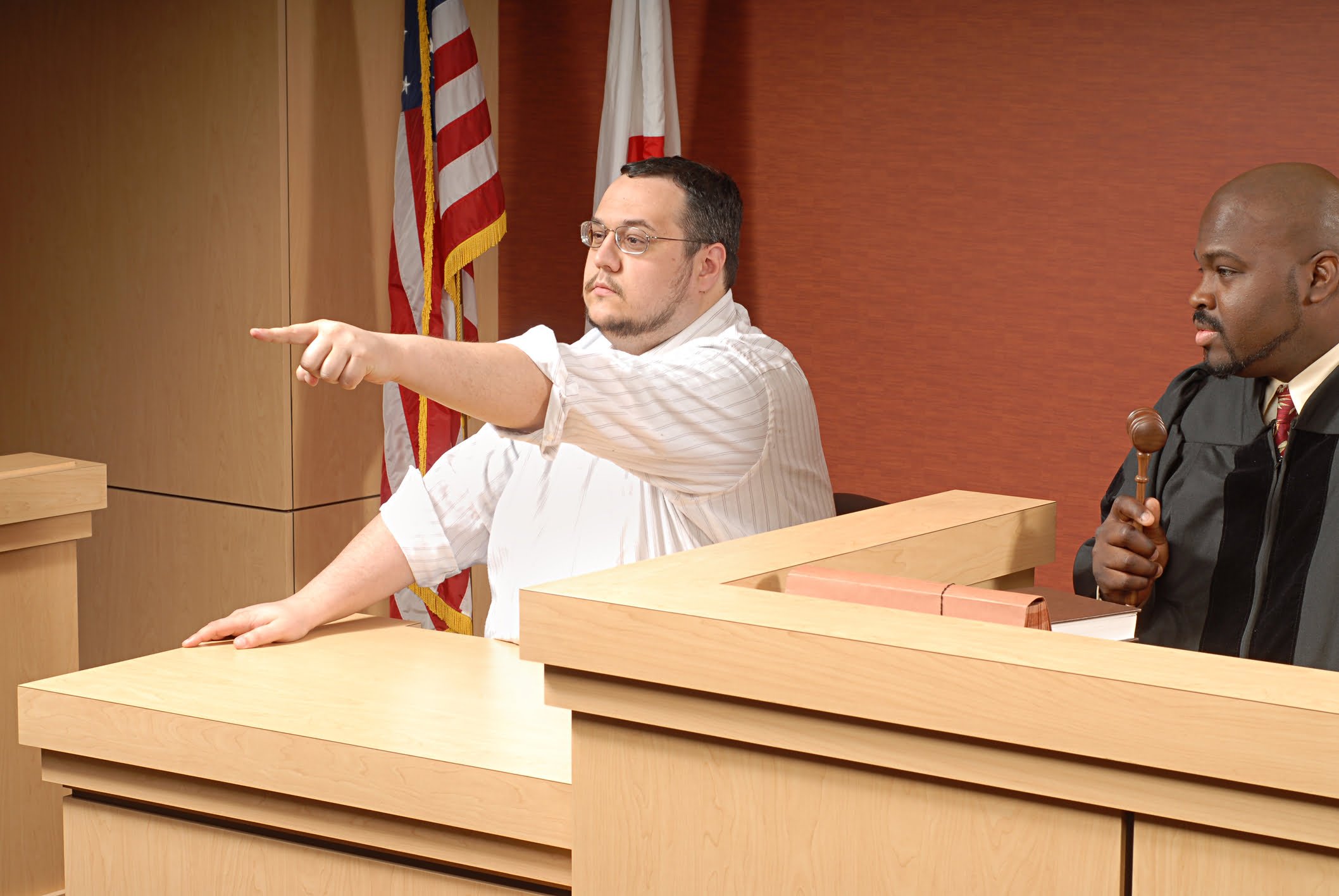 A man pointing while testifying in court.